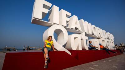 Visitors pose for photos with a FIFA World Cup sign in Doha on October 25, 2022, ahead of the Qatar 2022 FIFA World Cup football tournament. (Photo by Jewel SAMAD / AFP)