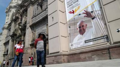 Una pancarta con la imagen del pontífice saluda a los traseúntes que pasan frente a la catedral de Lima.