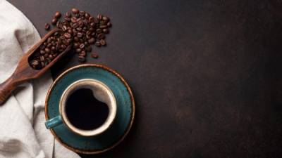 Coffee cup and beans on old kitchen table. Top view with copyspace for your text