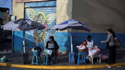 Dos mujeres venden tortillas el pasado sábado durante el toque de queda absoluto debido a las planes contra la propagación del Coronavirus en Tegucigalpa. EFE/Gustavo Amador