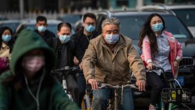 Personas se protegen con una mascarilla en China. Foto: AFP