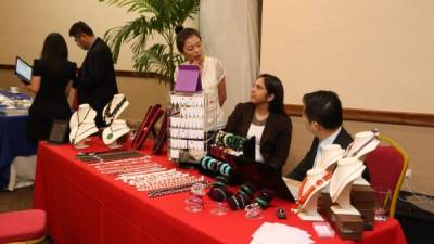 La traductora Michelle Huand -de pie- asesora a una potencial cliente en el “stand” de joyería fina. Fotos: Franklyn Muñoz