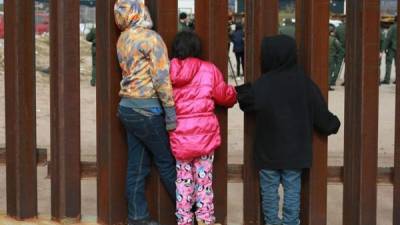 Un grupo de niños observan a agentes de migración de Estados Unidos en las cercanías del muro fronterizo en la ciudad de Tijuana en el estado de Baja California (México). EFE/Archivo