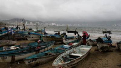 Pescadores ponen a resguardo sus barcazas hoy, viernes 13 de septiembre de 2013, en una playa de Acapulco en el estado mexicano de Guerrero. EFE/Archivo