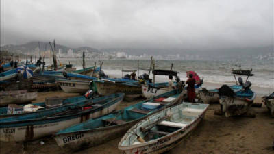 Pescadores ponen a resguardo sus barcazas hoy, viernes 13 de septiembre de 2013, en una playa de Acapulco en el estado mexicano de Guerrero. EFE/Archivo