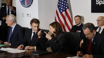 La vicepresidenta estadounidense Kamala Harris (2D) y el presidente francés Emmanuel Macron asisten a una reunión.