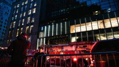 Miembros de la policía y del cuerpo de bomberos de Nueva York este sábado frente a la Torre Trump. EFE