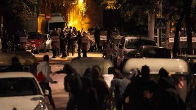 Los agentes antidisturbios se enfrentean a los manifestantes protegidos tras contenedores de basura durante los altercados que se produjeron anoche por las calles de Girona en la tercera jornada de protestas en Cataluña por la sentencia del 'procés'. EFE/David Borrat