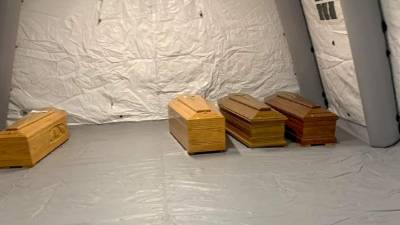 Esta foto proporcionada por la agencia de noticias italiana ANSA el 19 de marzo de 2020 muestra ataúdes alineados en una carpa en el hospital de Bérgamo, Lombardía, el 18 de marzo de 2020. Italia OUT / AFP / ANSA / STRINGER