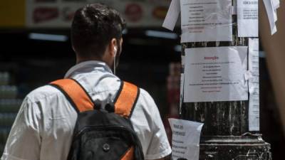 Un hombre revisa los avisos de empleo en una calle de Sao Paulo.