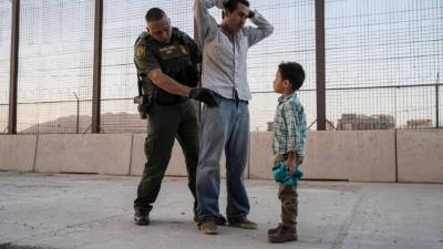 (FILES) In this file photo taken on May 16, 2019 José, 27, with his son José Daniel, 6, is searched by US Customs and Border Protection Agent Frank Pino, in El Paso, Texas. - The Trump administration moved on July 15, 2019 to block most migrants who cross the US southern border after passing through Mexico from seeking asylum.A new rule redefining asylum eligibility -- to take effect on Tuesday -- is the latest attempt to stem the flow of undocumented migrants into the country, and comes amid White House frustration at Congress's failure to change asylum laws. (Photo by Paul Ratje / AFP)