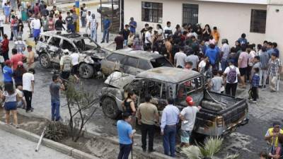 Decenas de personas observan los daños a varios vehículos luego de la explosión de un camión el pasado jueves, en el distrito de Villa El Salvador, en el sur de Lima (Perú). EFE/Paolo Aguilar
