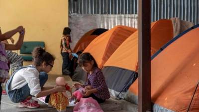 Niños migrantes juegan en las afueras de un albergue en Tijuana./AFP.