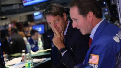 Corredores de bolsa trabajan en el piso de la plaza bursátil neoyorkina.