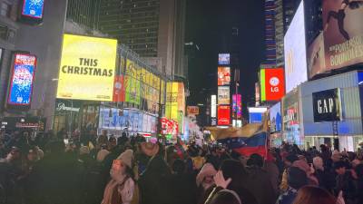 Ciudadanos venezolanos celebran durante una manifestación en el Times Square este sábado, en Nueva York (Estados Unidos).