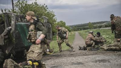 Militares ucranianos atienden a sus compañeros heridos durante un ataque rusos en la región del Donbás.