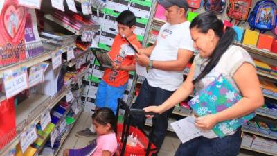 La familia Barrientos Escobar compra los útiles de sus dos hijos en una tienda antes del inicio de clases. Foto: Jorge Monzón