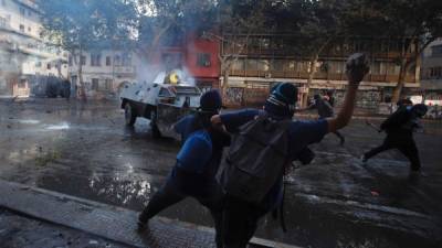 Manifestantes y Carabineros se enfrentan este martes en la céntrica Plaza Italia. EFE