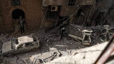 Varias personas caminan por un área destrozada tras un bombardeo en Duma (Siria). EFE/Archivo