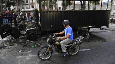 Un motociclista pasa por un lugar en donde hay protestas en Venezuela.