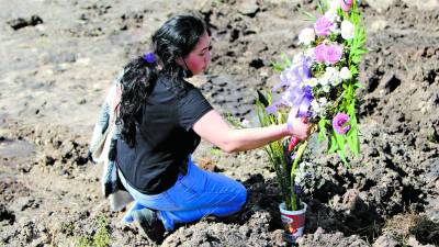 <b>María Celeste Aguilar coloca una ofrenda floral.</b>