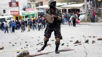 Agentes policiales proceden a quitar piedras de una de las vías tomadas en Tegucigalpa, capital de Honduras, por simpatizantes de la Alianza de Oposición.