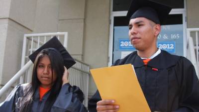 Los mexicanos Claudia Salazar, de 18 años y Daniel Alvarado, de 24 años, protestan hoy, jueves 14 de junio 2012, ante las oficinas de campaña en Charlotte del presidente, Barack Obama, para demandar que no se sigan separando familias de indocumentados. Vestidos con camisetas de colores llamativos y con la frase 'Indocumentados y sin miedo, no permaneceremos más en las sombras', una veintena de estudiantes gritaron 'acción ejecutiva ahora', en referencia al poder que tiene el presidente de detener las deportaciones de los estudiantes indocumentados que califican bajo el llamado Dream Act. El grupo de jóvenes intentó en vano entrar a las oficinas de campaña de Obama para entregar una carta en la que demandan un alivio migratorio a los soñadores. EFE/Alexandra Vilchez