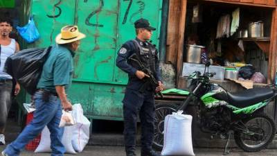Un policía resguarda una localidad de Tegucigalpa, previo a las elecciones generales a realizarse el domingo 26 de noviembre. / AFP PHOTO / ORLANDO SIERRA