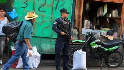 Un policía resguarda una localidad de Tegucigalpa, previo a las elecciones generales a realizarse el domingo 26 de noviembre. / AFP PHOTO / ORLANDO SIERRA