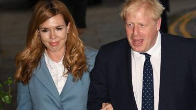 En esta foto de archivo tomada el 28 de septiembre de 2019, el primer ministro británico, Boris Johnson, camina con su compañera Carrie Symonds cuando llegan a The Midland, cerca del complejo de convenciones Manchester Central en Manchester, noroeste de Inglaterra, en la víspera de la conferencia anual del Partido Conservador.