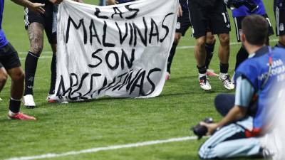 Jugadores de Argentina sostienen una pancarta que dice 'Las Malvinas son argentinas' al celebrar su victoria frente a Inglaterra.