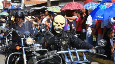 Un hombre en motocicleta hace la señal de amor y paz.