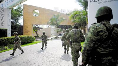 Soldiers patrol near an apartment complex in Cuernavaca, Mexico, Thursday, Dec. 17, 2009. A Mexican navy official said that alleged drug cartel chief Arturo Beltran Leyva and three members of his organization were slain Wednesday inside an apartment of the complex during a shootout with sailors. (AP Photo/Miguel Tovar)