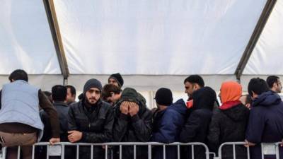 Grupo de refugiados espera en fila a ser atendido en un centro de acogida de Berlín, capital alemana.