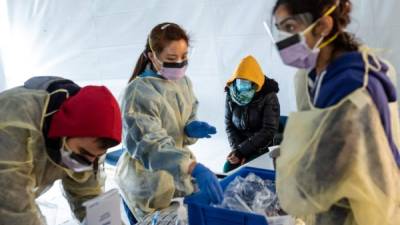 Personal médico se protege para realizar pruebas de Covid-19 en Nueva York. Foto: AFP