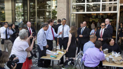 El presidente de EE.UU., Barack Obama (c), saluda a varias personas tras caminar desde la Casa Blanca hasta el restaurante Taylor Gourmet, donde compró comida para llevar, en la Avenida Pennsylvania de Washington (EE.UU.), el 4 de octubre de 2013. EFE