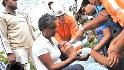 Civil Defense personnel assist Katherine Zapata (C), relative of a miner, after 'La Preciosa' coal mine exploded in Corregimiento San Roque, Sardinata municipality, department of Norte de Santander, Colombia on January 26, 2011. According to officials, five people were killed, six were injured and sixteen miners remain trapped inside the mine. AFP PHOTO/Guillermo Legaria
