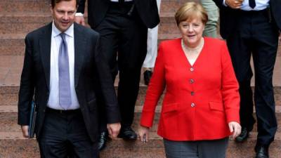 La canciller alemana, Angela Merkel y el portavoz del Gobierno germano, Steffen Seibert. EPA/SASCHA STEINBACH/Archivo
