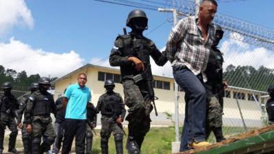 Los reos son custodiados por la Policía Militar mientras suben a los convoy.
