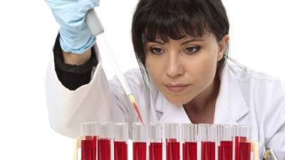 Scientist, pathologist or other lab worker takes a sample from a test tube