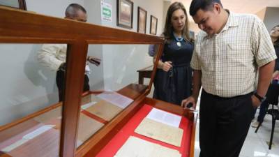La directora del Archivo Histórico Judicial, Dilcia Valle, y el universitario Robin Cruz observan el testamento.