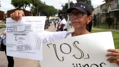 La directora de la organización comunitaria Mujeres Trabajadoras Inmigrantes, Luz Ortiz, sostienen un cartel y una hoja informativa con teléfono durante un recorrido para ofrecer información sobre los derechos de los inquilinos en un barrio de alta población latina en el suroeste de Houston, Texas. EFE