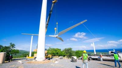 Trabajadores montando la estructura en una planta de energía eólica en la isla de Roatán.