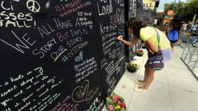 Samantha Lepore, estudiante de la Universidad de California Santa Barbara (UCSB), fue registrada este martes la dejar un mensaje en un muro de recuerdos, cerca al sitio donde siete personas murieron y otras 13 resultaron heridas en medio de un tiroteo, en la localidad universitaria de Isla Vista, en Santa Bárbara (California, EE.UU.). EFE