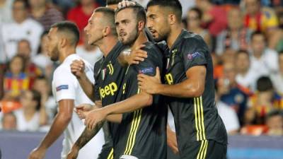 Miralem Pjanic es felicitado por sus compañeros de la Juventus tras marcar el segundo gol ante el Valencia. Foto EFE