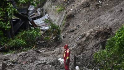 Un rescatador participa en la búsqueda de 7 personas que fueron enterradas por un deslizamiento de tierra. Foto: AFP