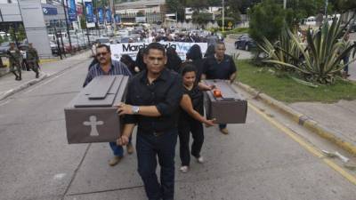 Además del paro de buses, los transportistas realizaron una manifestación por la vida en el que cargaron ataúdes de cartón y en el que mujeres vestidas de negro simulaban las viudas de los conductores asesinados.
