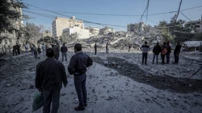 Varios palestinos inspeccionan los destrozos registrados en una zona residencial tras un ataque aéreo israelí en la ciudad de Gaza. EFE