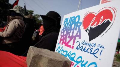 Un grupo de personas armadas y enmascaradas observas mientras se lleva a cabo una actividad conmemorativa al 'repliegue táctico' de los sandinistas en Masaya, Nicaragua. EFE