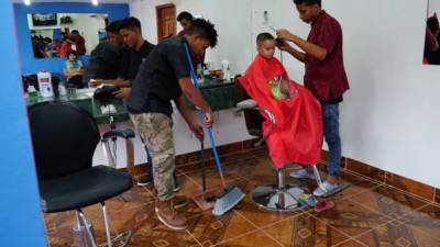 Los hermanos Nelson y Gerson Ruiz junto a su amigo Oney Medina atienden el negocio de la peluquería. Fotos: CRistina santos.